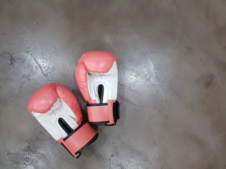 Picture of red boxing gloves laying on the floor.