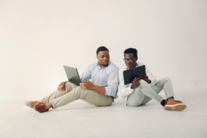 deux hommes jeunes travaillent ensemble en utilisant des laptops