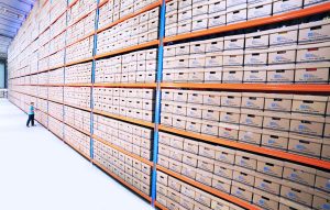Photo of very tall shelves of boxes filled with archival materials.