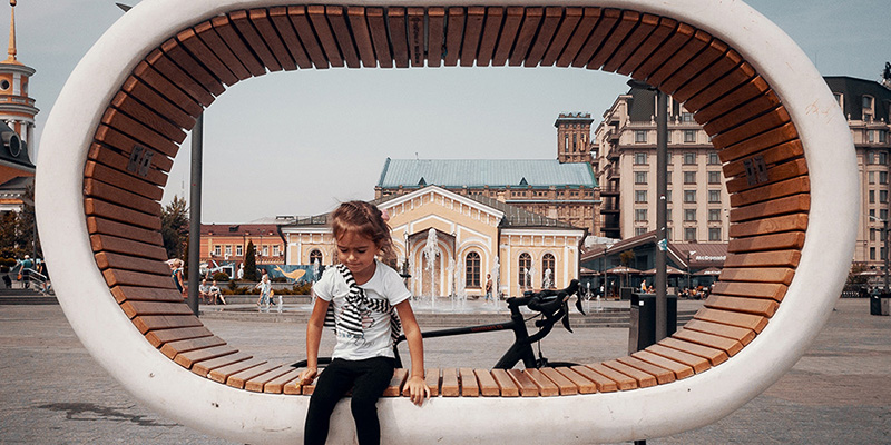 child sitting on a circular bench