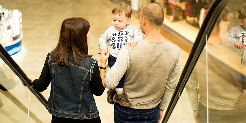 family standing on an escalator