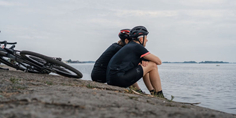 bikers sitting by water