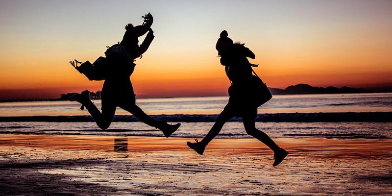 people jumping with a sunset