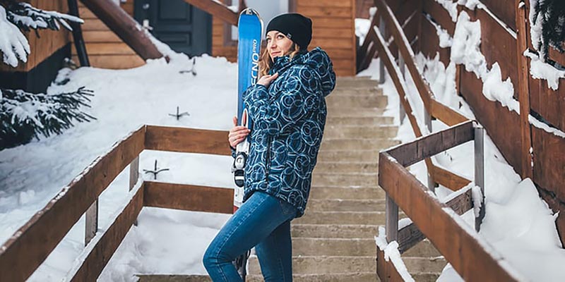 women holding a snowboard by stairs