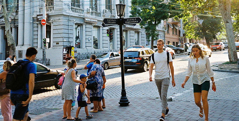 people walking by a street sign