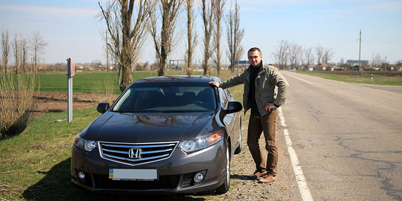 man standing next to a car