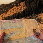 person holding map with mountains in background