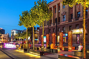 outdoor scene in city with benches in front of art installation