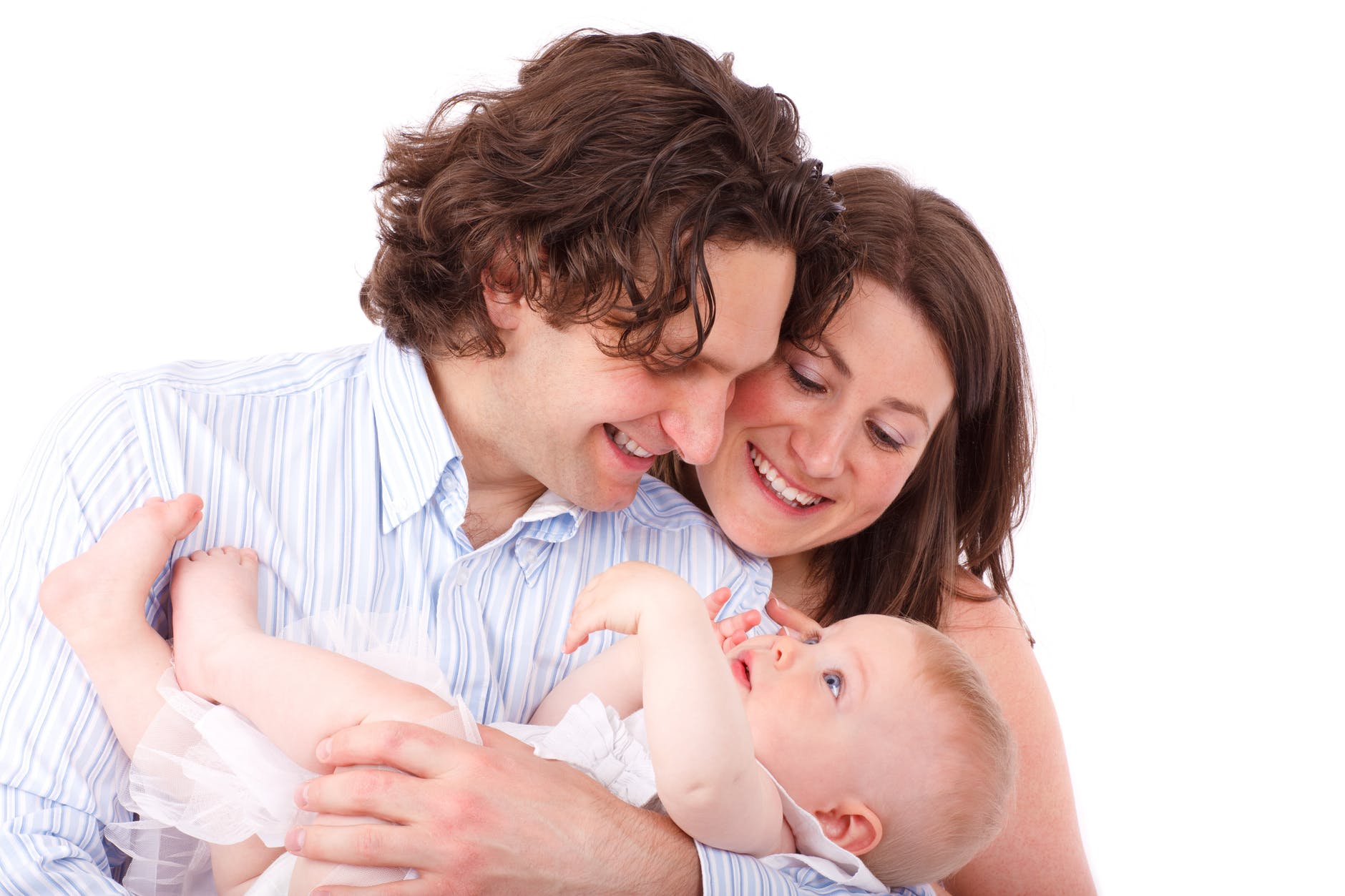 father holding infant child with mother resting her head on father's shoulder looking at baby