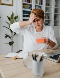 Woman balancing ledger at desk.