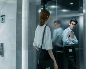 Woman warily enters elevator with overconfident looking guy.