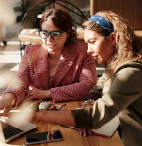 Two Women Meeting in a Cafe Over a Laptop.